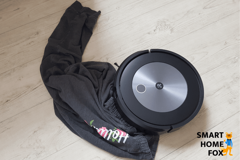 Man sieht den iRobot Roomba j7+ wie sich dieser an einer Hose festfährt
